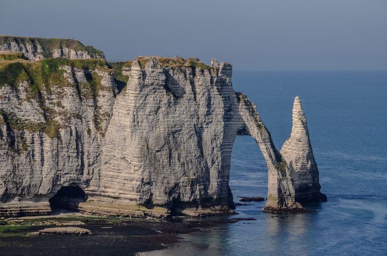 Dramatic sea cliffs and rock arches at Étretat, Normandy, France offer stunning natural beauty.